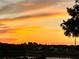 Stunning sunset view overlooking the lake and community homes and lush landscape at 2615 Autumn Green Dr, Orlando, FL 32822