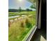 Scenic view of the golf course through a window, highlighting lush greenery and peaceful surroundings at 2615 Autumn Green Dr, Orlando, FL 32822