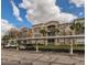Condo complex with covered parking, landscaped grounds, and light stucco exterior at 3025 Greystone Loop # 302, Kissimmee, FL 34741