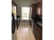 Kitchen featuring tile flooring, dark wood cabinets, granite countertops, and stainless steel appliances at 3567 Conroy Rd # 1213, Orlando, FL 32839
