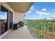 Outdoor balcony with seating and sliding glass doors with views of landscaped gardens at 4 Oceans West Blvd # 301B, Daytona Beach Shores, FL 32118