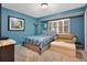 The bedroom has blue walls, neutral carpet and a comfy couch at 4 Oceans West Blvd # 301B, Daytona Beach Shores, FL 32118