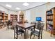 Inviting community room with tables, chairs, computer, and bookshelves at 4 Oceans West Blvd # 301B, Daytona Beach Shores, FL 32118
