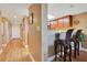 Hallway with wood floors leads to front door and the kitchen area with barstool seating and overhead lighting at 4 Oceans West Blvd # 301B, Daytona Beach Shores, FL 32118