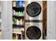 A laundry area features a stacked washer and dryer and shelf with cleaning supplies at 4 Oceans West Blvd # 301B, Daytona Beach Shores, FL 32118