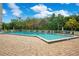 A rectangular pool is surrounded by green trees and blue skies at 4 Oceans West Blvd # 301B, Daytona Beach Shores, FL 32118