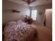 Well-lit bedroom with a floral-patterned bedspread, work desk, and bright window at 4328 S Kirkman Rd # 1, Orlando, FL 32811
