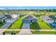 Aerial view of a well-maintained blue home with a long driveway, surrounded by green lawns and neighborhood at 452 Burnham Cir, Auburndale, FL 33823
