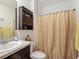 Bathroom features a vanity and shower with patterned curtain at 452 Burnham Cir, Auburndale, FL 33823