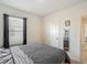 A serene bedroom with a patterned bedspread, a window with dark curtains, and a convenient closet at 452 Burnham Cir, Auburndale, FL 33823