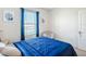 This bedroom offers a blue bedspread, lots of light from the window, and charming decor at 452 Burnham Cir, Auburndale, FL 33823