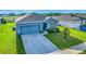 Charming blue single-Gathering home with a well-maintained lawn, long driveway, and manicured landscaping at 452 Burnham Cir, Auburndale, FL 33823