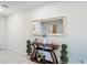 Elegant hallway featuring a stylish console table, decorative mirror, and tiled floor at 452 Burnham Cir, Auburndale, FL 33823