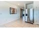 Bright kitchen area featuring stainless steel refrigerator, tile flooring, and a view of the hallway and bedroom at 452 Burnham Cir, Auburndale, FL 33823