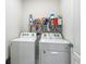 Efficient laundry room with washer, dryer, and storage shelf filled with cleaning supplies at 452 Burnham Cir, Auburndale, FL 33823