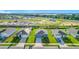 A neighborhood view of three homes that feature well-manicured lawns, driveways, and landscaping with a view of a lake at 452 Burnham Cir, Auburndale, FL 33823