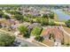 Aerial view of home in a residential neighborhood with lush greenery and a tranquil lake nearby at 5365 Dahlia Reserve Dr, Kissimmee, FL 34758