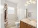 This bathroom has a large vanity with cabinets and drawers, a tub, and a seashell-themed shower curtain at 5365 Dahlia Reserve Dr, Kissimmee, FL 34758