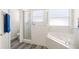 Bathroom featuring glass-enclosed shower and corner bathtub with tiled surround at 5365 Dahlia Reserve Dr, Kissimmee, FL 34758