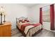 This cozy bedroom offers a comfortable bed, dresser and a window with bright red curtains at 5365 Dahlia Reserve Dr, Kissimmee, FL 34758
