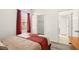 Bedroom with wood-look flooring, red curtains, and access to another room and closet at 5365 Dahlia Reserve Dr, Kissimmee, FL 34758