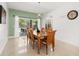 Dining room with a wooden table set for six, complemented by a view of the inviting pool area at 5365 Dahlia Reserve Dr, Kissimmee, FL 34758