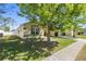 Well-maintained front yard with mature landscaping, a driveway, and partial view of the house's facade at 5365 Dahlia Reserve Dr, Kissimmee, FL 34758