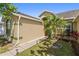 Beautifully landscaped front yard with a vibrant palm tree, lush greenery, and a walkway to the home's entrance at 5365 Dahlia Reserve Dr, Kissimmee, FL 34758