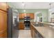 Well-lit kitchen features stainless steel appliances, tile flooring and wood cabinetry at 5365 Dahlia Reserve Dr, Kissimmee, FL 34758