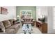 Inviting living room with plush seating, a glass coffee table, and a view of the outdoors through the window at 5365 Dahlia Reserve Dr, Kissimmee, FL 34758