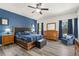 Bedroom featuring a king bed, wood furniture, and a blue accent wall at 5365 Dahlia Reserve Dr, Kissimmee, FL 34758