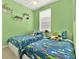 Vibrant ' bedroom with two twin beds, playful decor, and bright green walls at 541 Campus St, Celebration, FL 34747