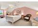 Bright bedroom featuring pink walls, a comfortable seating area, and a cozy queen size bed at 541 Campus St, Celebration, FL 34747