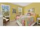 Inviting yellow bedroom with large windows offering ample sunlight and a cozy quilt at 541 Campus St, Celebration, FL 34747