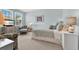 Bright blue bedroom featuring a large window with blinds and comfortable furnishings at 541 Campus St, Celebration, FL 34747