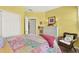 Charming yellow bedroom with a decorative quilt, a wicker chair, and natural light at 541 Campus St, Celebration, FL 34747
