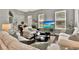 Bright living room with white sofas, decorative pillows, and a view of a tropical scene on the TV at 541 Campus St, Celebration, FL 34747
