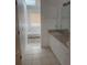 Bright bathroom with a soaking tub, tiled floors, and a well-lit vanity at 567 Caribbean Dr, Davenport, FL 33897