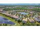 Aerial view of the property by a pond, featuring mature trees, and nicely landscaped homes at 567 Villa Park Rd, Kissimmee, FL 34759