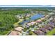 An elevated angle of roofs in a neighborhood beside a lake surrounded by trees at 567 Villa Park Rd, Kissimmee, FL 34759