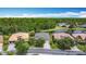 Aerial view of a landscaped property with a lake, trees, and a house with a grey roof at 567 Villa Park Rd, Kissimmee, FL 34759