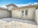 An expansive backyard features stone paver flooring, a large backyard wall, and double doors to inside the home at 567 Villa Park Rd, Kissimmee, FL 34759