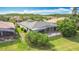 Expansive backyard featuring a screened patio, lush grass, and mature palm trees at 567 Villa Park Rd, Kissimmee, FL 34759