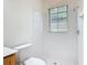 Bathroom featuring bright white tiles, a toilet, a window, and a shower stall at 567 Villa Park Rd, Kissimmee, FL 34759