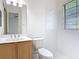 Clean bathroom with single vanity, toilet and a window, showcasing a minimalist design and ample lighting at 567 Villa Park Rd, Kissimmee, FL 34759