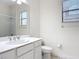 Bright bathroom features a white single sink vanity and toilet at 567 Villa Park Rd, Kissimmee, FL 34759