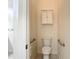 Cozy half bathroom features grab bars and a wall cabinet for accessible and convenient storage at 567 Villa Park Rd, Kissimmee, FL 34759