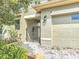 A quaint view of the garage entrance and walk-in entrance with a metal gate and stone paver flooring at 567 Villa Park Rd, Kissimmee, FL 34759
