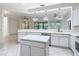 Bright kitchen featuring white cabinets, stainless steel appliances, an island, and a bar pass through at 567 Villa Park Rd, Kissimmee, FL 34759