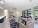 Bright, staged living room with neutral furniture, glass coffee table, white walls, and view to the outdoors at 567 Villa Park Rd, Kissimmee, FL 34759